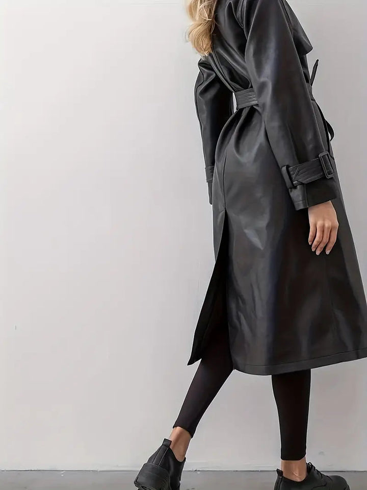 Back view of women’s long black faux-leather trench coat with waist tie and rear slit