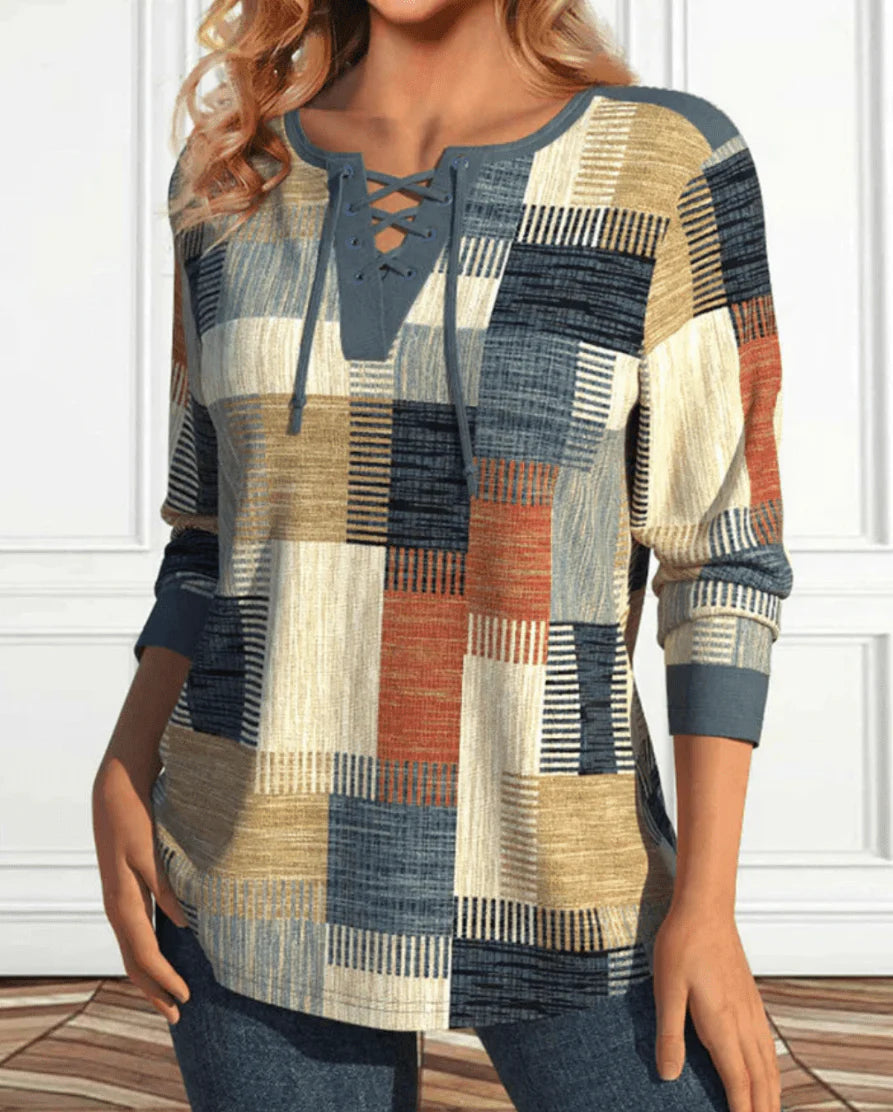Women’s long-sleeve patchwork top with lace-up neckline in blue, beige and rust tones.