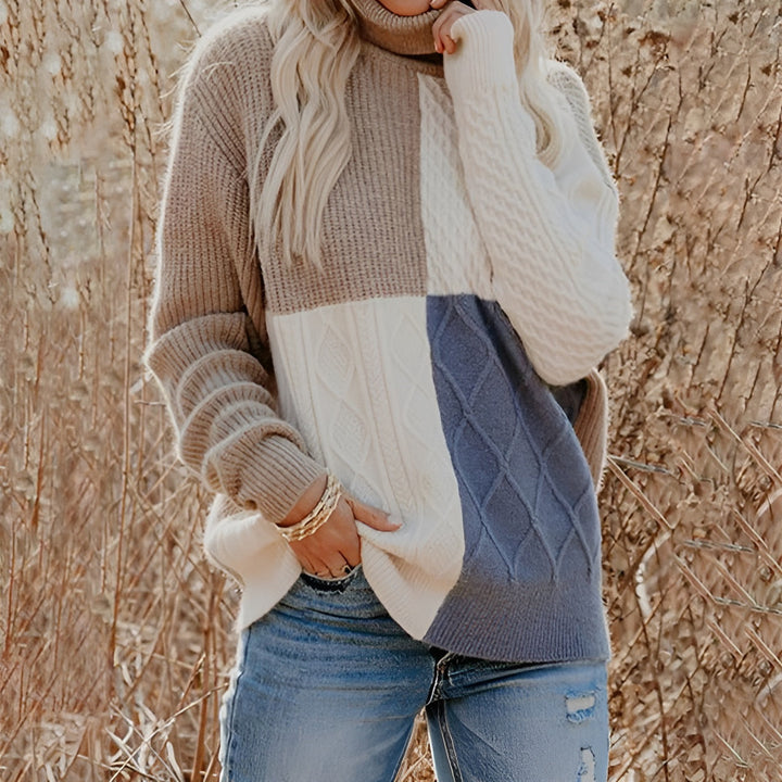 Women’s colour-block turtleneck sweater with cable-knit pattern in beige, white and blue.