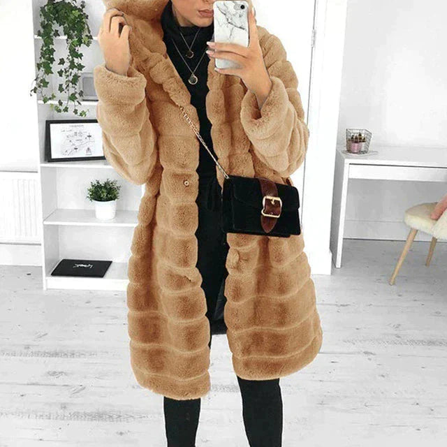 Women’s long beige faux-fur hooded coat styled with a black crossbody bag