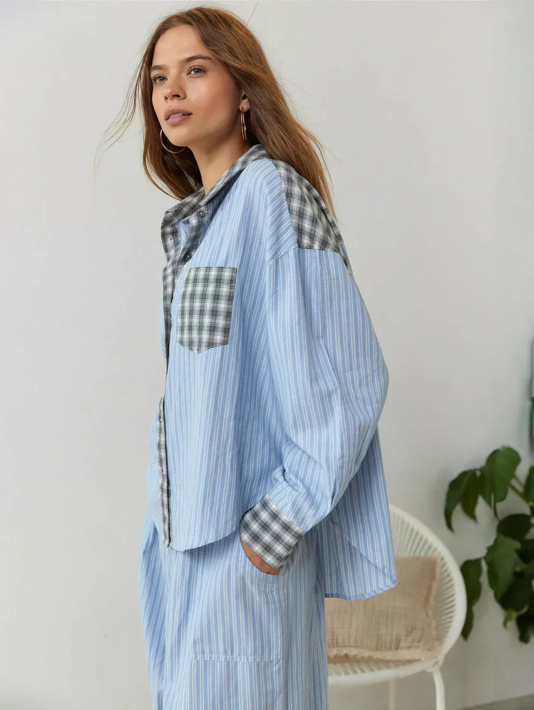 Woman wearing a light blue checkered outfit with a white background